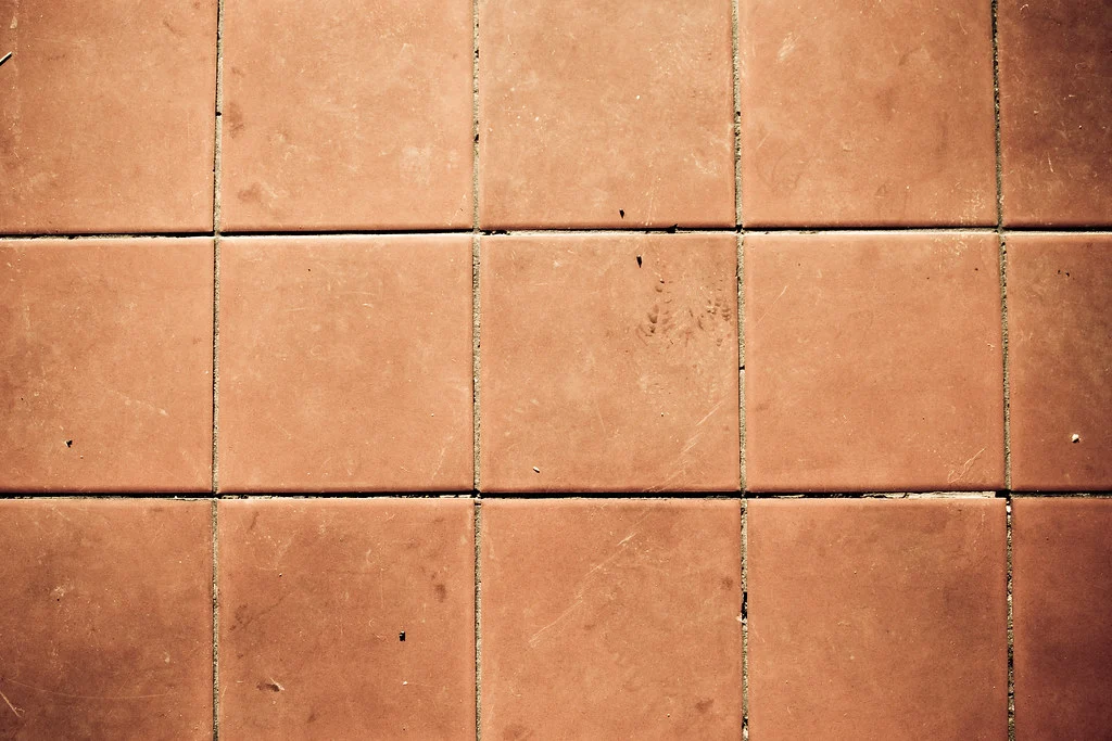 Natural stone floor tiles in an architectural interior, showing grain and light movement across the surface